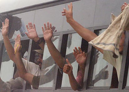 Prisioneros iraquíes saludan desde un autobús tras ser liberados en mayo de la prisión de Abu Ghraib.
