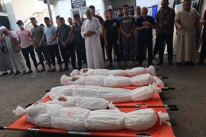 Allegados rezan ante los cuerpos de los miembros de una misma familia muertos en un bombardeo israelí, en el hospital de Al Najar, antes de su funeral en Rafah, en el sur de la Franja.