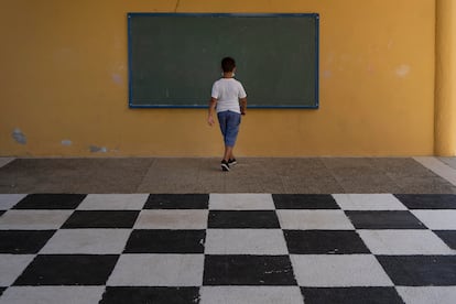 Un alumno, de espaldas en el patio del colegio.