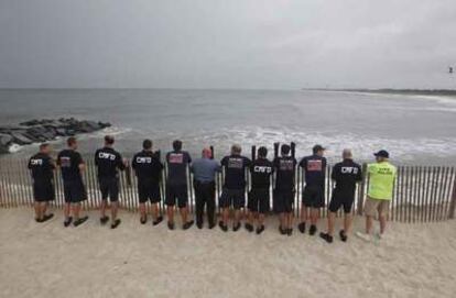 Miembros del equipo de emergencias de Cape May, en el Estado de Nueva Jersey, contemplan el estado del mar mientras el huracán Irene se acerca a la costa.