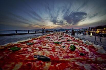 Una pizza napolitana de dos kilómetros de largo, elaborada para batir el récord del mundo, y colocada a lo largo del paseo marítimo en Nápoles (Italia).