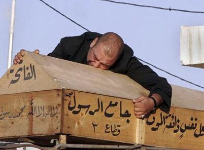 Un iraquí llora sobre el féretro de su esposa, una de las víctimas de los atentados de ayer en Bagdad