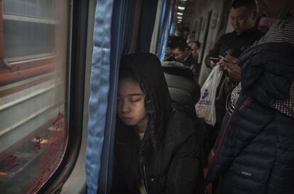 Un viajero duerme en el tren mientras realiza el trayecto entre Pekín y Shijiazhuang.