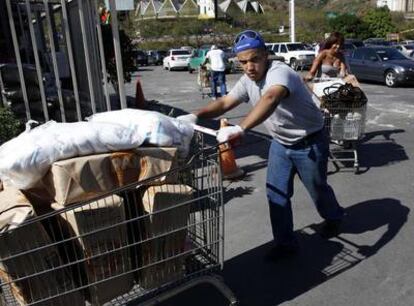 Un hombre compra alimentos en Caracas ante el temor a que se disparen los precios, en un hipermercado abierto ayer.