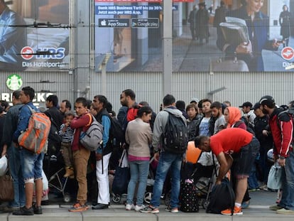 Decenas de migrantes aguardan para coger un tren en una estaci&oacute;n de M&uacute;nich (Alemania), en septiembre de 2015. 