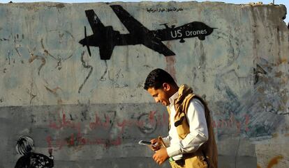 Un yemení pasa frente a un graffiti contrario a los bombardeos estadounidenses en el país.
