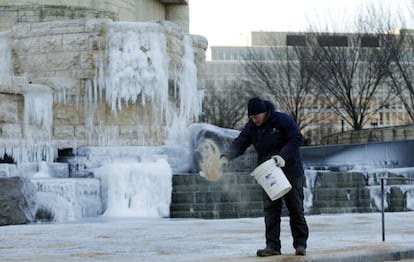 Un trabajador tira sal al suelo en el exterior del Museo Nacional de los Indígenas Americanos en Washington.