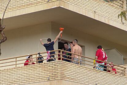 Jóvenes británicos beben en un balcón, a través de un embudo.