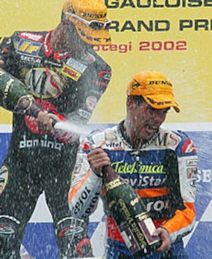 Melandri riega con cava a Toni Elías en el podio, tras el triunfo del español.