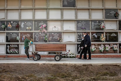 A coronavirus victim is laid to rest in Valencia, accompanied by family members.