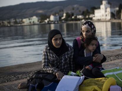 Una familia siria aguarda en el muelle tras llegar a la isla griega  de Kos.