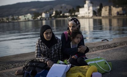 Una familia siria aguarda en el muelle tras llegar a la isla griega  de Kos.