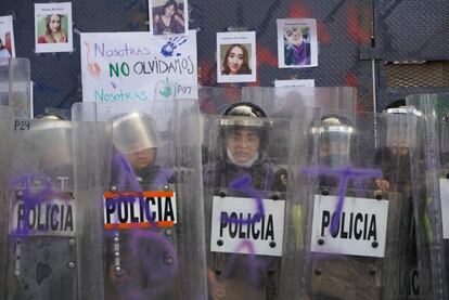 Un grupo de mujeres policías hace guardia frente a una valla en el centro histórico de Ciudad de México.