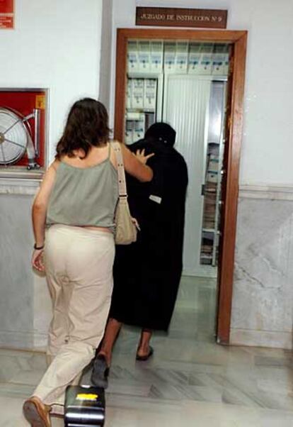 Una policía de paisano acompaña a una de las cuatros inmigrantes, que acuden como testigos protegidos para declarar en el caso de presuntos abusos sexuales en el Centro de Internamiento de Extranjeros de Málaga.
