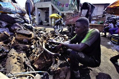 Un trabajador de Agbogbloshie revisa los restos de motores de motocicletas para seleccionar las partes que pueden ser vendidas a los comerciantes locales, que luego las llevan a empresas que los utilizan como insumos. 