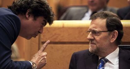 Jorge Moragas (l) speaks to Mariano Rajoy.