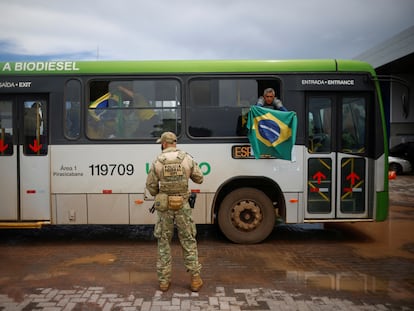 Un partidario de Jair Bolsonaro sostenía una bandera al llegar en autobús a la Academia Nacional de la Policía Federal en Brasilia, el lunes.