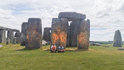 Dos activistas del grupo ecologista Just Stop Oil, este miércoles, tras rociar con pintura naranja el monumento megalítico de Stonehenge, en el suroeste de Inglaterra.