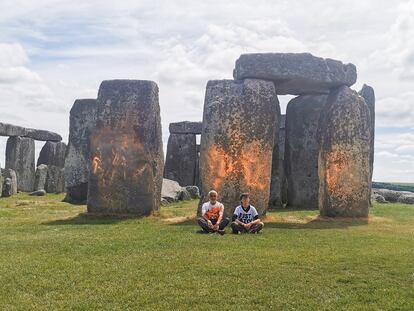 Dos activistas del grupo ecologista Just Stop Oil, este miércoles, tras rociar con pintura naranja el monumento megalítico de Stonehenge, en el suroeste de Inglaterra.
