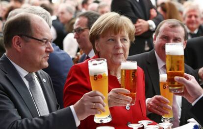 La canciller alemana,Angela Merkel, junto al ministro de Agricultura y Alimentaci&oacute;n alem&aacute;n, Christian Schmidt (izquierda), brinda durante una ceremonia de la Ley de la pureza de la cerveza en Ingolstadt, Alemania.