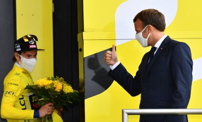 El presidente francés, Emmanuel Macron, hace un gesto al corredor del equipo Jumbo Primož Roglič, vestido con el maillot amarillo de líder de la general, tras ganar la 17ª etapa, entre las localidades de Grenoble y Meribel, el 16 de septiembre.
