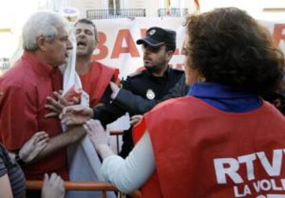 Trabajadores de RTVV forcejean con la policía a las puertas del Palau de la Generalitat tras la reunión que ha mantenido el comité de empresa con entidades y organizaciones contrarias al proceso de extinción de RTVV.
