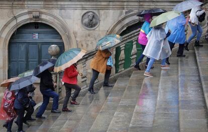 Varios turistas bajo la lluvia en la plaza de Platerías de Santiago de Compostela. Una borrasca al oeste de Finisterre dejó varios chubascos en la comunidad, donde los embalses se encuentran muy bajos de capacidad para esta época del año.