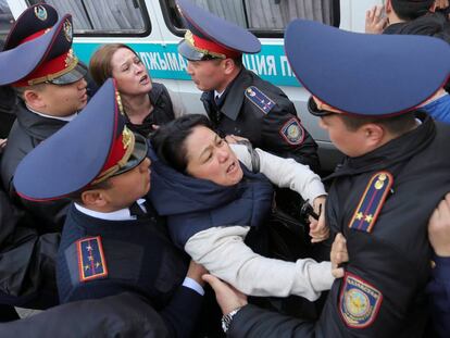 Policías retienen a una manifestante opositora al Gobierno este viernes en Almaty.
