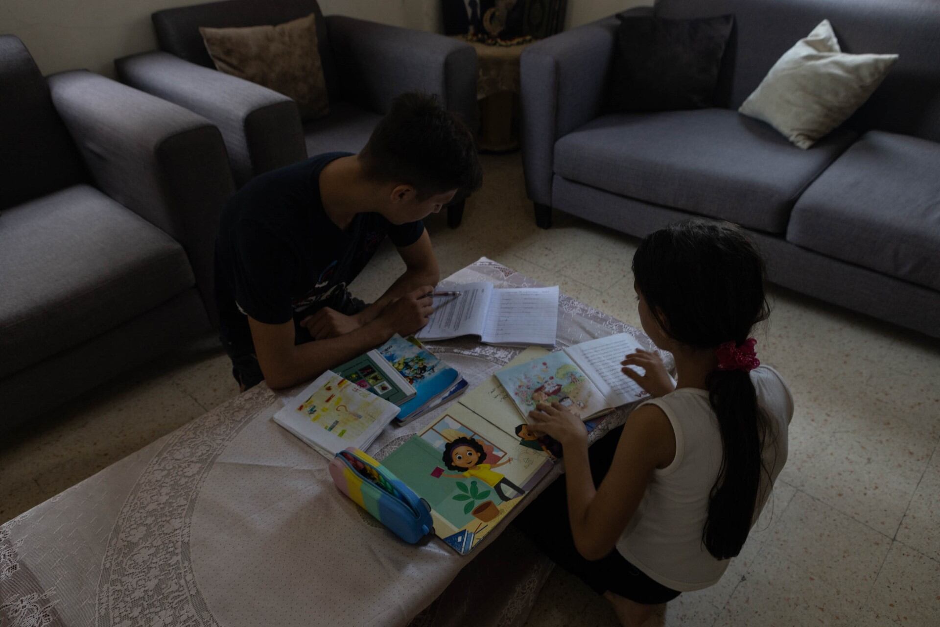 Hamsa y Maya repasan sus cuadernos del colegio, aunque no sepan si podrán regresar a las clases en octubre.