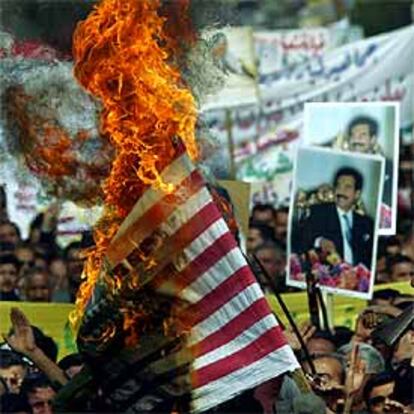 Quema de una bandera de EE UU ayer en la marcha de Bagdad.