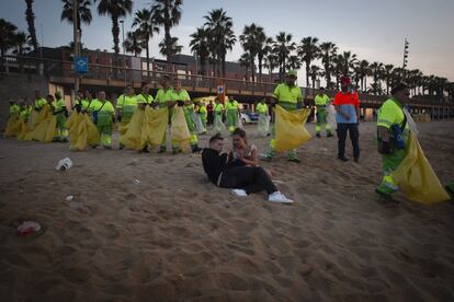 Limpieza de la playa de la Barceloneta tras la verbena de San Juan, en Barcelona.
