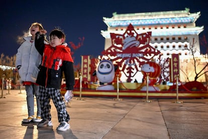 Una niña y un niño posan frente a las mascotas de los Juegos Olímpicos, este lunes en Pekín. 
