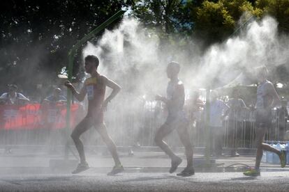 Los corredores de los 20 km marcha pasan por una de las zonas de refreco instaladas durante el recorrido