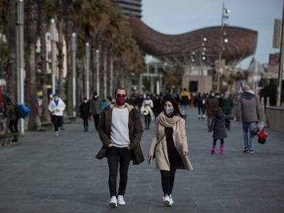 Varias personas protegidas con mascarillas pasean por el paseo marítimo de Barcelona el 23 de enero.