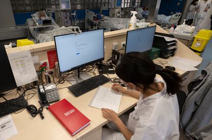 Una sanitaria del Hospital Clínic de Barcelona trabaja tomando notas a mano después del ciberataque, el lunes.