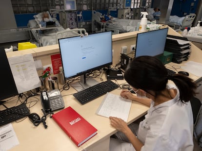 Una sanitaria del Hospital Clínic de Barcelona trabaja tomando notas a mano este lunes después del ciberataque "complejo" sufrido el 6 de marzo.