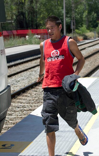 El joven llega al andén tras cruzar por la vía y se dirige al tren.