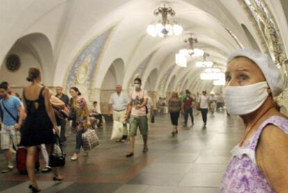 Una mujer de avanzada edad se protege del humo con una mascarilla en los pasillos del metro de Moscú.