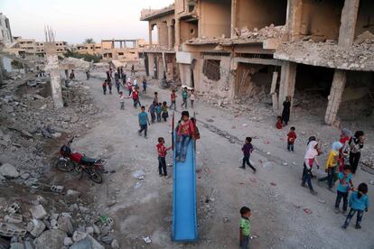 Un grupo de niños sirios que huyeron de sus casas en la ciudad de Ghouta al-Marj juegan entre los escombros de edificios en la ciudad de al-Nashabiyah, al este de Damasco.