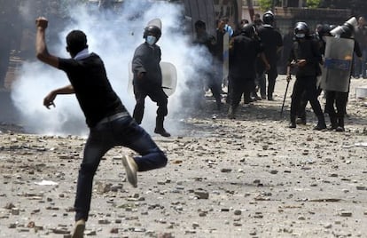 Un manifestante lanza una lata de gas lacrim&oacute;geno contra un polic&iacute;a en los disturbios junto a la embajada de EE UU en El Cairo.