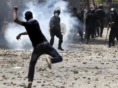 Un manifestante lanza una lata de gas lacrim&oacute;geno contra un polic&iacute;a en los disturbios junto a la embajada de EE UU en El Cairo.