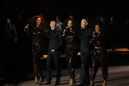 Dean y Dan Caten saludan al final del desfile que marca el 25º aniversario de la marca junto a Sister Sledge.