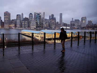 Un hombre camina por una calle desierta ante el 'skyline 'de Manhattan.