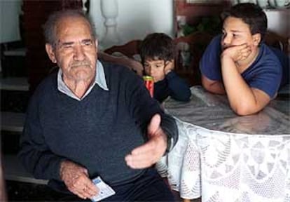 Agustín Gómez y dos de sus nietos, en su casa de Vélez Málaga.