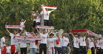 Los jugadores del Sevilla subidos a la estatua de Hispalis, en la Puerta de Jerez.