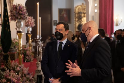 El presidente de la Junta de Andalucía, Juanma Moreno (izquierda), junto a el Hermano Mayor de la Hermandad de Triana, Sergio Sopeña Carriazo (derecha), durante la visita a la Capilla de los Marineros. Sevilla (Andalucía, España), a 29 de marzo 2021.