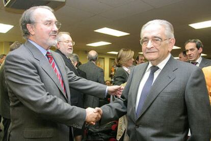 Pedro Solbes saluda a Luis Ángel Rojo durante el acto en la Universidad Complutense de Madrid.