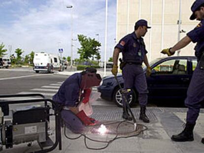 Varios agentes sueldan la tapa de registro de una alcantarilla cercana a la sede de la cumbre UE-América Latina.