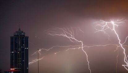 Varios rayos caen junto a un edificio comercial durante una tormenta en Colombo (Sri Lanka).