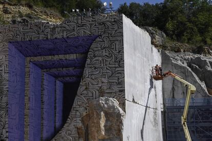 El artista francés del graffiti, Loïc Monde, pinta en una pared de una cantera de piedra caliza.
